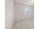 A bright bedroom featuring neutral carpet, light walls, and a window for natural light at 3413 Dragonfly River Ct, Raleigh, NC 27604