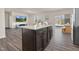 Kitchen island featuring granite countertop and dark cabinetry adjacent to the breakfast nook and living room at 3413 Dragonfly River Ct, Raleigh, NC 27604