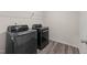 A laundry room with modern appliances and wood-style flooring at 3413 Dragonfly River Ct, Raleigh, NC 27604