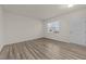 Clean and inviting living room featuring wood floors, a window, and a white interior door at 3413 Dragonfly River Ct, Raleigh, NC 27604