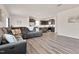 Spacious living room with gray sectional sofa, flowing seamlessly into a modern kitchen with dark cabinetry at 3413 Dragonfly River Ct, Raleigh, NC 27604