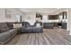 Open-concept living room with a gray sectional sofa and views into a modern kitchen with a dark wood island at 3413 Dragonfly River Ct, Raleigh, NC 27604