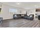 Open-concept living room with gray sectional sofa, kitchen access, and abundant natural light at 3413 Dragonfly River Ct, Raleigh, NC 27604