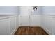 Hallway with hardwood floors, wainscoting, and neutral paint at 345 Rubrum Dr, Hillsborough, NC 27278