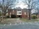 Three-story brick apartment building with mature trees and marked parking spaces at 3520 Ivy Commons Dr # 302, Raleigh, NC 27606