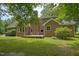 Backyard view of the brick home featuring a cozy deck and lush green grass, perfect for outdoor enjoyment at 3560 Nc 98, Youngsville, NC 27596