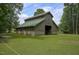 Sturdy barn with a green roof and wooden siding, standing on a lush grassy area at 3560 Nc 98, Youngsville, NC 27596