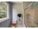 Cozy bathroom featuring a shower with glass doors, patterned wallpaper and a bright window at 3560 Nc 98, Youngsville, NC 27596