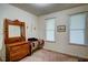 Bedroom with neutral carpet, two windows, and traditional wood furniture, offering a simple, peaceful retreat at 3560 Nc 98, Youngsville, NC 27596