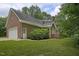 Well-maintained brick home with an attached garage, side entry door, and manicured landscaping at 3560 Nc 98, Youngsville, NC 27596