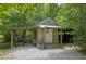 Rustic outbuilding with covered areas, offering practical outdoor storage and workspace, surrounded by lush trees at 3560 Nc 98, Youngsville, NC 27596
