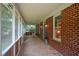 Inviting screened-in porch featuring a swing, brick accents and charming, rustic details at 3560 Nc 98, Youngsville, NC 27596