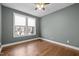 Empty bedroom with hardwood floors and a large window providing ample natural light at 3916 Bostwyck Dr, Fuquay Varina, NC 27526