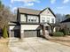 Inviting two-story home boasts a three-car garage and a charming red front door at 3916 Bostwyck Dr, Fuquay Varina, NC 27526
