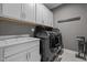 Laundry room with modern washer/dryer, upper cabinets, sink, and quartz countertop at 3916 Bostwyck Dr, Fuquay Varina, NC 27526