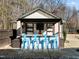 Outdoor bar with seating, a corrugated metal roof, mounted TV, and custom shelving at 3916 Bostwyck Dr, Fuquay Varina, NC 27526