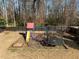 Fenced backyard features a colorful playground set for with surrounding trees at 3916 Bostwyck Dr, Fuquay Varina, NC 27526