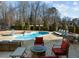 Sparkling pool, surrounded by patio furniture and overlooking lush greenery with privacy fence at 3916 Bostwyck Dr, Fuquay Varina, NC 27526