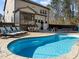 Backyard pool surrounded by ample lounge seating, patio and screened porch area in sunny backyard at 3916 Bostwyck Dr, Fuquay Varina, NC 27526