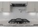 Close up on modern gas cooktop with sleek vent hood and white subway tile backsplash at 3916 Bostwyck Dr, Fuquay Varina, NC 27526