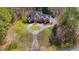 Aerial of a brick two-story home with circle drive, manicured lawn and mature trees at 400 Tharps Ln, Raleigh, NC 27614