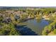 A broad aerial view of Swan's Mill with mature trees surrounding a scenic lake at 400 Tharps Ln, Raleigh, NC 27614