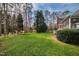The backyard with a grassy lawn and woods behind the house at 400 Tharps Ln, Raleigh, NC 27614