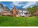 View of the home's backyard with a brick section, white siding, and a screened-in porch at 400 Tharps Ln, Raleigh, NC 27614