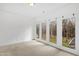 Bedroom with white walls and large doors overlooking lush greenery at 400 Tharps Ln, Raleigh, NC 27614