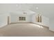 Expansive bonus room with plush neutral carpet, ample natural light, and a ceiling fan at 400 Tharps Ln, Raleigh, NC 27614