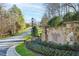 Stone 'Swan's Mill' entrance sign featuring manicured flower beds, lamp post and views of the community road and landscaping at 400 Tharps Ln, Raleigh, NC 27614