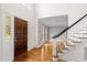 Welcoming foyer featuring hardwood floors, a staircase, and a well-lit entryway at 400 Tharps Ln, Raleigh, NC 27614