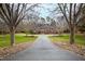 Elegant brick home with mature trees lining a long driveway, creating a private, estate-like setting at 400 Tharps Ln, Raleigh, NC 27614