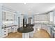 Spacious kitchen with island cooktop, granite countertops, and white cabinetry at 400 Tharps Ln, Raleigh, NC 27614