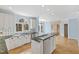 Well-lit kitchen with island cooktop, granite countertops, and white cabinetry at 400 Tharps Ln, Raleigh, NC 27614