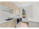 Well-equipped laundry room with washer, dryer, sink, and storage cabinets at 400 Tharps Ln, Raleigh, NC 27614