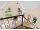 View from the top of the stairs of the living room with fireplace and tall windows at 400 Tharps Ln, Raleigh, NC 27614