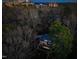 Aerial dusk view of the home surrounded by tall trees with the city skyline in the background at 402 Westwood Dr, Chapel Hill, NC 27516