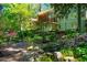 Backyard with a deck, patio, and rock waterfall surrounded by landscaping at 402 Westwood Dr, Chapel Hill, NC 27516