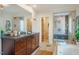 Bright bathroom featuring a walk-in shower and dual vanities with granite countertops at 402 Westwood Dr, Chapel Hill, NC 27516