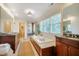 Bright bathroom featuring a soaking tub, a walk-in shower, and dual vanities with granite countertops at 402 Westwood Dr, Chapel Hill, NC 27516