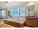 Bright bathroom featuring a soaking tub, a walk-in shower, and a plant by the tub at 402 Westwood Dr, Chapel Hill, NC 27516