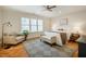Bright bedroom with hardwood floors, neutral decor, ceiling fan and a cozy seating area by the window at 402 Westwood Dr, Chapel Hill, NC 27516