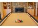 Close-up of billiards table, with set pool balls and a warm cozy room with fireplace at 402 Westwood Dr, Chapel Hill, NC 27516