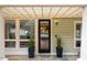Home front door with a glass storm door, 2 potted plants and a stone entryway at 402 Westwood Dr, Chapel Hill, NC 27516