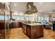 Spacious kitchen with a stainless hood, stone counters, and an island cooktop at 402 Westwood Dr, Chapel Hill, NC 27516