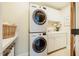 Practical laundry room featuring a stacked washer and dryer, storage cabinets, and a utility sink at 402 Westwood Dr, Chapel Hill, NC 27516