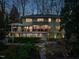 Spacious, green two-story home featuring large back deck and stone patio overlooking the landscaped yard at 402 Westwood Dr, Chapel Hill, NC 27516