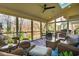 Spacious screened porch features wicker furniture, a ceiling fan, and a view of the surrounding trees at 402 Westwood Dr, Chapel Hill, NC 27516