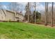 Spacious backyard with lush green grass, mature trees, and a wooden fence at 415 King George Loop, Cary, NC 27511